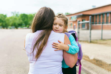 Mother and her daughter to school. Giving a big hugの写真素材