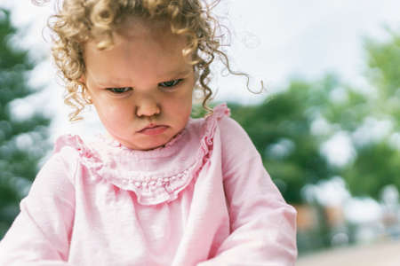 Young girl sitting on the floor at the school playgroundの写真素材