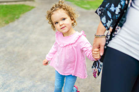 nice mother having fun in summer forest with his child girl holding handの写真素材