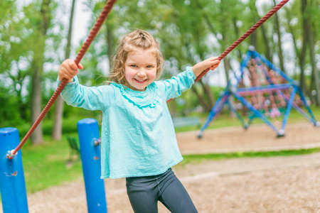 Happy little girl is playground having funの写真素材