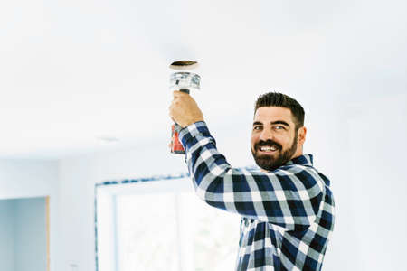 Portrait of an electrician happy worker at work install lightの写真素材