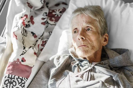 Sick, elderly senior woman in a hospital bed