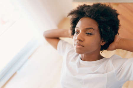 young African female relaxing on a chair in the kitchen