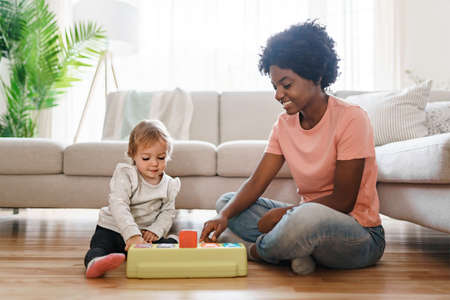 nursery babysitter with baby play with toys