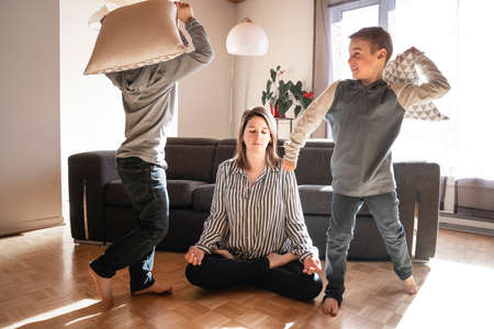 Unhappy Caucasian mom suffer from headache stressed tired by naughty small son playing.の写真素材