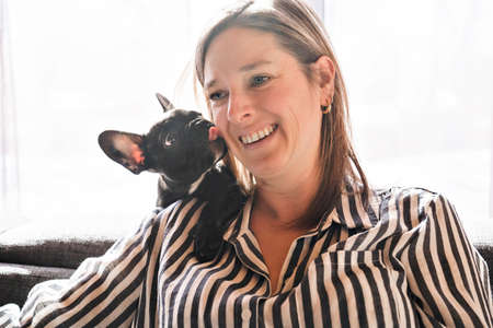 Portrait of happy adult at home with french bulldogの写真素材