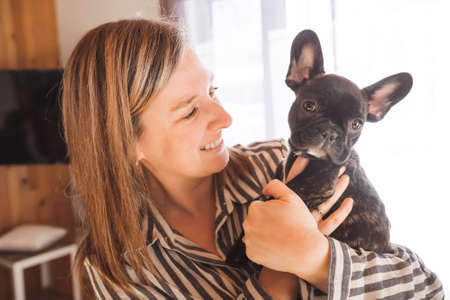 Portrait of happy adult at home with french bulldogの写真素材