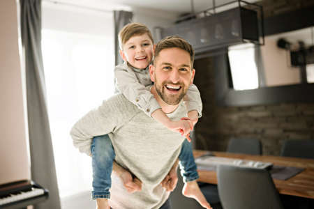 Father or godfather having fun on the living room At Home on his back