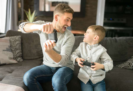 Father or Godfather having fun on the living room At Home play video gameの写真素材