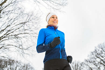 Nice Young Woman Running in Snowy Park