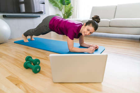 Attractive Fit woman Exercise at home on the living room