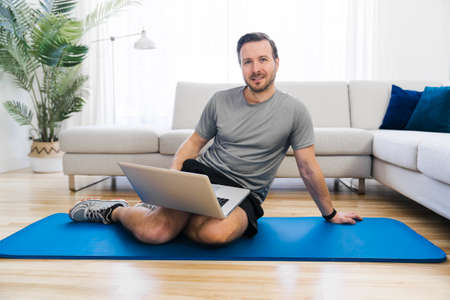 Attractive Fit man Exercise at home on the living roomの写真素材