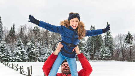 Handsome dad and his daughter are having fun outdoor in winter