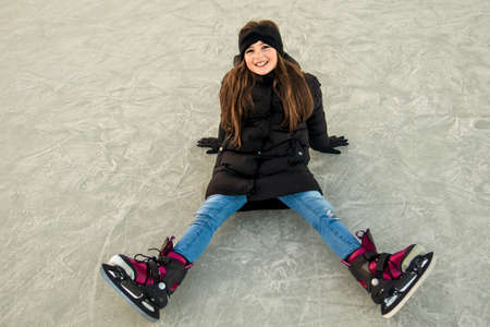 pretty cheerful little girl in thermal suits skating outdoors
