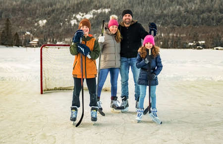 portrait of happy hockey family on a lakeの写真素材