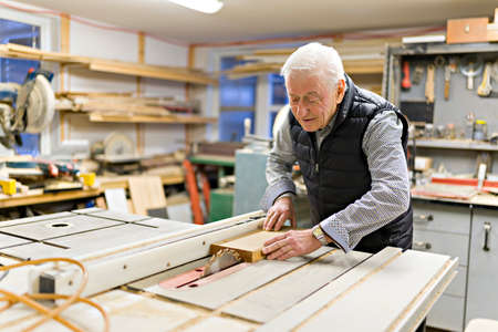 senior grandpa in the home workshop workingの写真素材