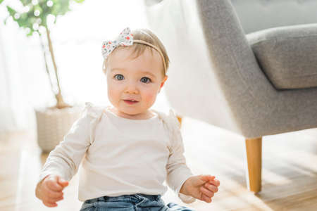 Portrait of a baby girl having fun in the living room sofa in a room,