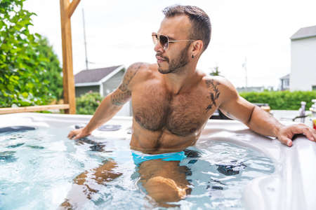 sexy mexican man relaxing in hot tub on summer seasonの写真素材