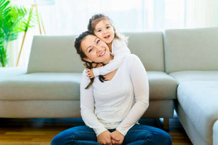 Mother with her daughter having fun in living room at home