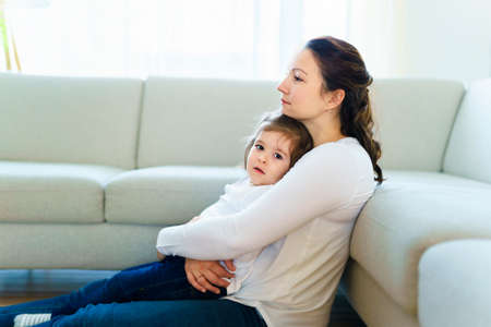 Mother with her daughter relaxing in living room at homeの写真素材