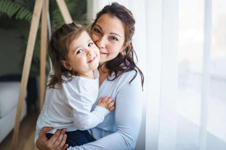 Mother with her daughter having fun in living room at homeの写真素材