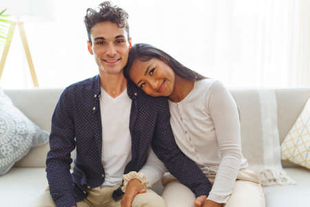 european couple in living room having fun on the sofa