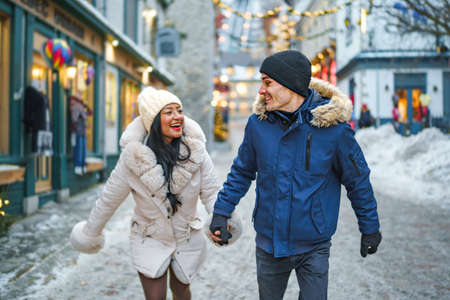 Portrait of a beautiful young couple on a christmas background with bokeh lightsの写真素材