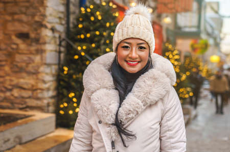 Portrait of a beautiful young model on a christmas background with bokeh lightsの写真素材