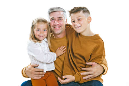 Father and daughter and son having fun together on studio whiteの写真素材