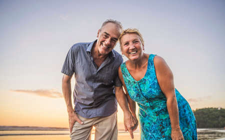 Senior Couple Enjoying Beautiful Sunset on the Beachの写真素材