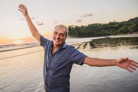 Senior men having great time on beach at the sunsetの写真素材