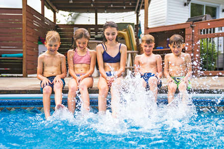group of children having fun in Pool on the summer time