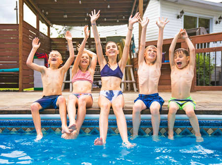 group of children having fun in Pool on the summer time
