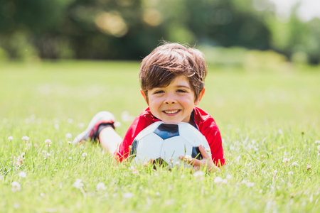 Young soccer player having fun on a field with ballの写真素材