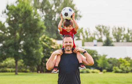 Young soccer player having fun on a field with his fatherの写真素材