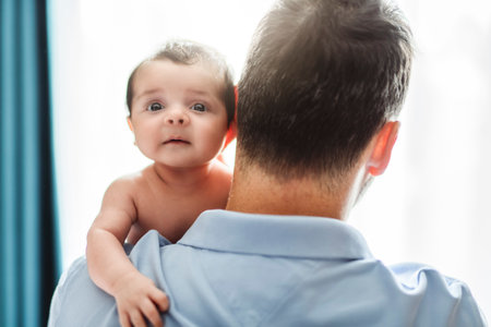 father on bedroom with his newborn baby sonの写真素材
