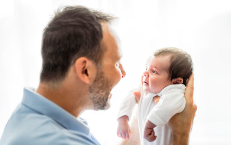 father on bedroom with his newborn baby sonの写真素材