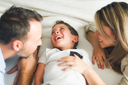father and mother on bedroom with his sonの写真素材