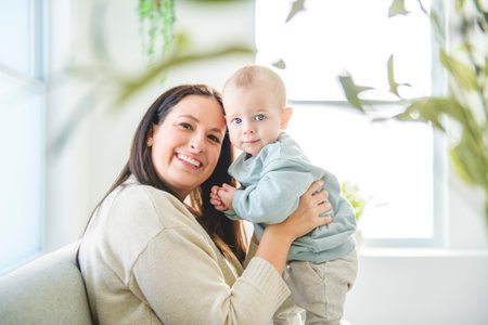 Happy young mother enjoying time with her adorable toddler son at home