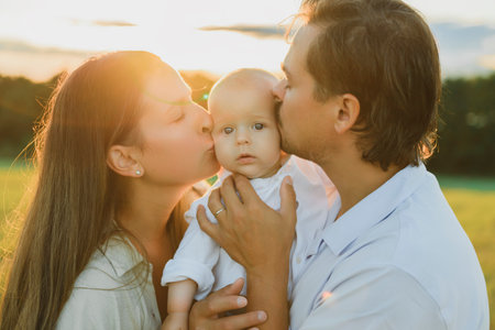 Happy family with baby boy on nature sunset