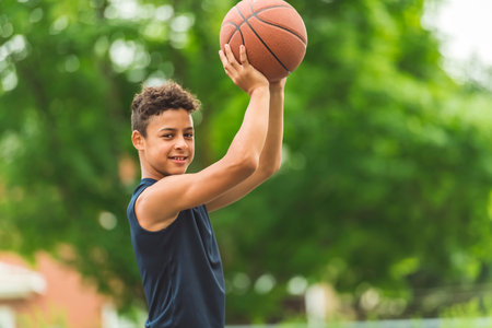 portrait of a boy kid playing with a basketball in parkの写真素材