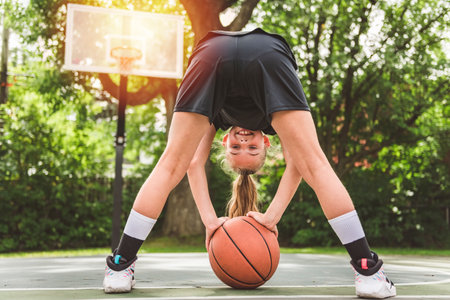 girl with basketball on court on summer seasonの写真素材