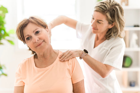 Physiotherapist working with elderly patient in clinic