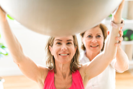 elderly Physiotherapist working with sporty patient in clinicの写真素材