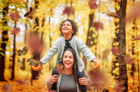 mother and daughter having fun in autumn parkの写真素材