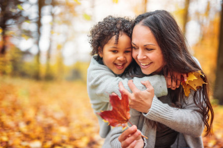 mother and daughter having fun in autumn park