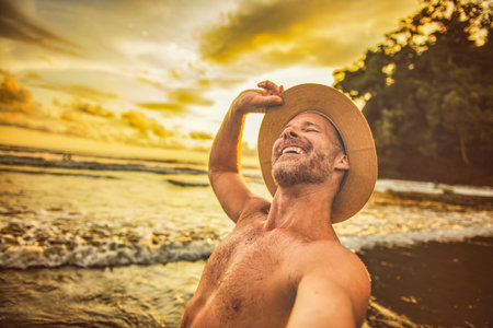 nice man taking selfie portrait on beachの写真素材