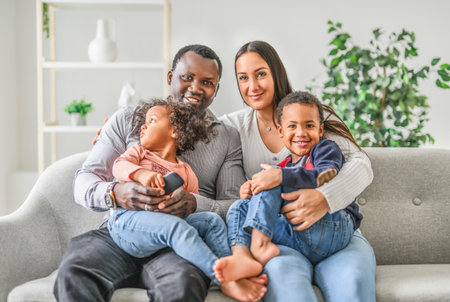family with boy and girl child posing on photo shooting, sitting on couchの写真素材