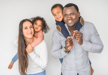 family with boy and girl child posing on photo shooting on white backgroundの写真素材