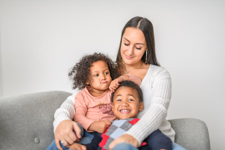 family with boy and girl child posing on photo shooting, sitting on couchの写真素材